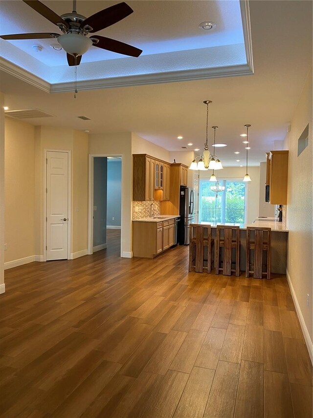 1167 Motorcoach Dr, Polk City, FL 33868 - kitchen with freestanding refrigerator, brown cabinets, a raised ceiling, glass insert cabinets, and recessed lighting