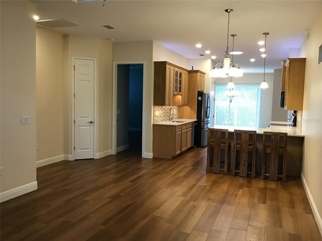 1167 Motorcoach Dr, Polk City, FL 33868 - kitchen with freestanding refrigerator, a chandelier, dark wood-type flooring, light countertops, and glass insert cabinets
