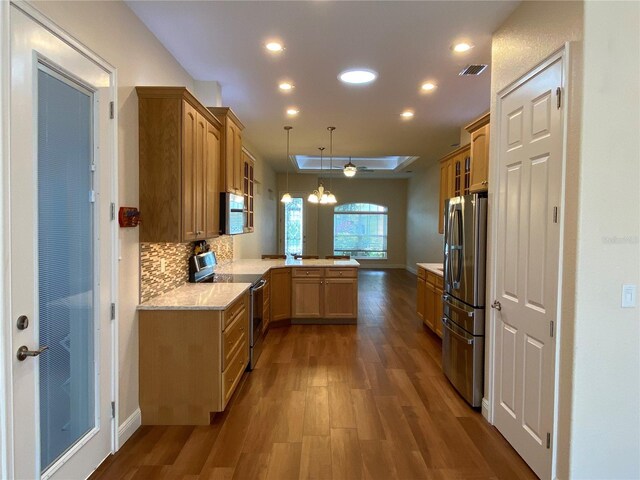 1167 Motorcoach Dr, Polk City, FL 33868 - kitchen with stainless steel appliances, a peninsula, wood finished floors, recessed lighting, and tasteful backsplash