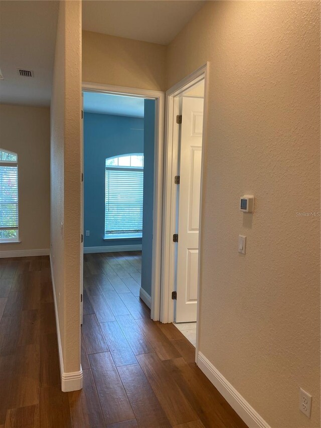 1167 Motorcoach Dr, Polk City, FL 33868 - hallway featuring dark wood-type flooring, baseboards, and a textured wall