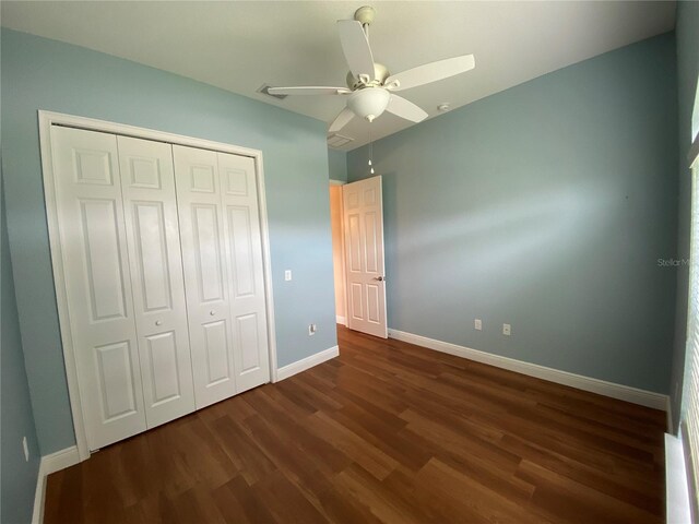1167 Motorcoach Dr, Polk City, FL 33868 - unfurnished bedroom featuring baseboards, dark wood-style floors, a closet, and a ceiling fan