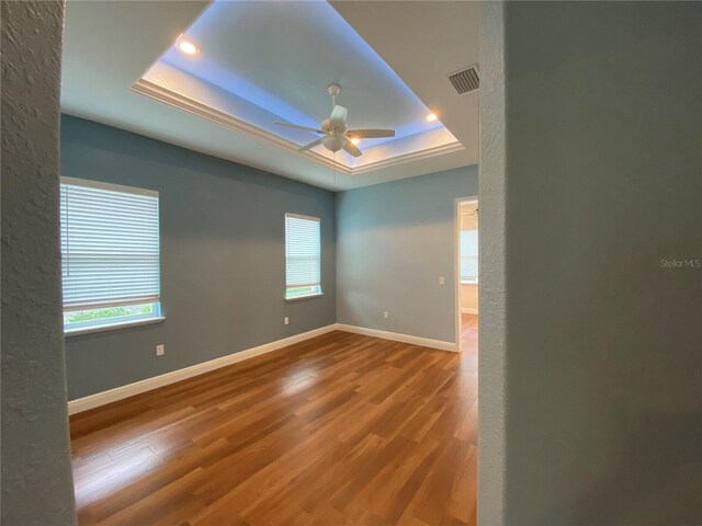 1167 Motorcoach Dr, Polk City, FL 33868 - empty room featuring a raised ceiling, a ceiling fan, wood finished floors, recessed lighting, and baseboards