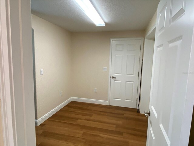 1167 Motorcoach Dr, Polk City, FL 33868 - unfurnished room featuring dark wood-style flooring, baseboards, and a textured ceiling