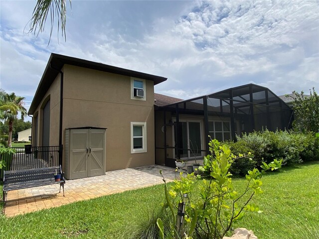 1167 Motorcoach Dr, Polk City, FL 33868 - rear view of property with stucco siding, a lawn, a patio area, and a lanai