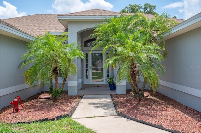 6789 Ashbury Dr, Lakeland, FL 33809 - view of exterior entry with a shingled roof and stucco siding