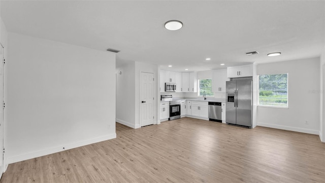 408 Sycamore St SW, Fort Meade, FL 33841 - kitchen featuring appliances with stainless steel finishes, light wood-style floors, white cabinets, light countertops, and baseboards