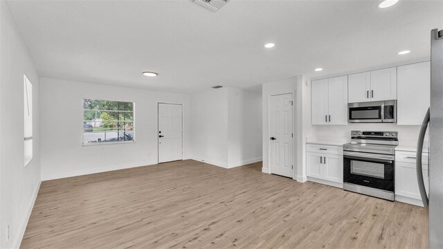 408 Sycamore St SW, Fort Meade, FL 33841 - kitchen featuring appliances with stainless steel finishes, light wood-type flooring, recessed lighting, white cabinets, and light countertops
