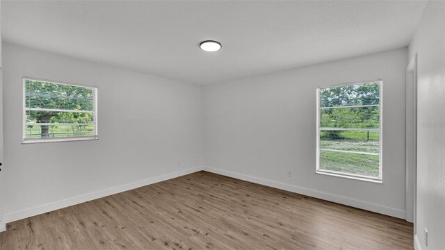 408 Sycamore St SW, Fort Meade, FL 33841 - unfurnished room featuring wood finished floors, healthy amount of natural light, and baseboards
