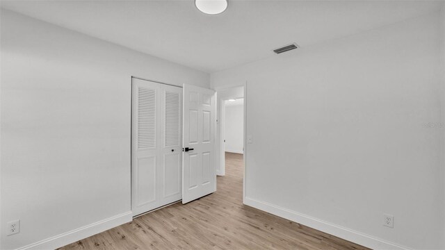 408 Sycamore St SW, Fort Meade, FL 33841 - unfurnished bedroom featuring baseboards, light wood finished floors, and a closet