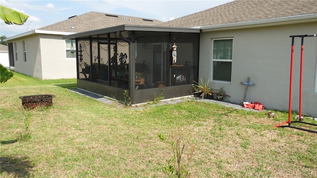 550 Patton Loop, Bartow, FL 33830 - back of house with a sunroom, a shingled roof, a fire pit, and a yard