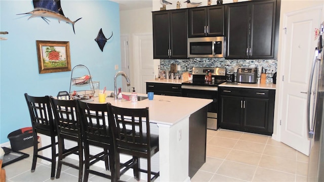550 Patton Loop, Bartow, FL 33830 - kitchen featuring appliances with stainless steel finishes, dark cabinets, tasteful backsplash, and light countertops