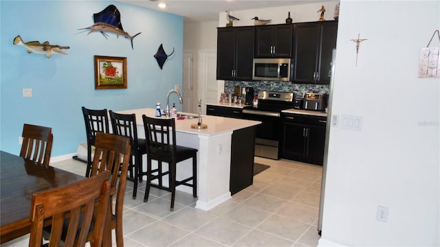 550 Patton Loop, Bartow, FL 33830 - kitchen featuring appliances with stainless steel finishes, dark cabinetry, light countertops, and light tile patterned flooring