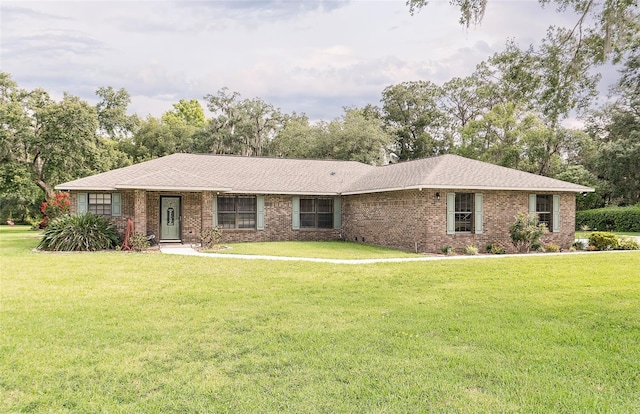 2331 D R Bryant Rd, Lakeland, FL 33810 - ranch-style house with a front lawn, brick siding, and view of wooded area