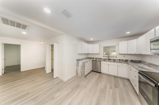 113 Patrick Henry Rd, Bartow, FL 33830 - kitchen with stainless steel appliances, white cabinetry, light wood-style flooring, light stone countertops, and recessed lighting