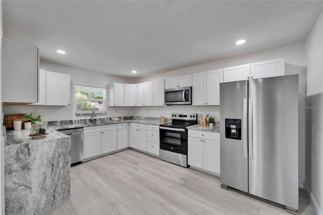 113 Patrick Henry Rd, Bartow, FL 33830 - kitchen featuring appliances with stainless steel finishes, white cabinetry, light stone countertops, light wood-style flooring, and recessed lighting