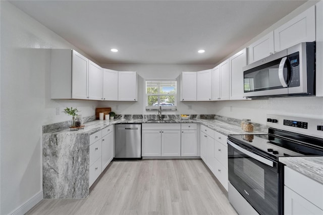 113 Patrick Henry Rd, Bartow, FL 33830 - kitchen with appliances with stainless steel finishes, light wood-style flooring, light stone countertops, white cabinetry, and recessed lighting