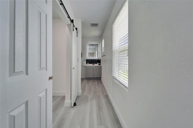 113 Patrick Henry Rd, Bartow, FL 33830 - hall featuring a barn door and light wood-type flooring