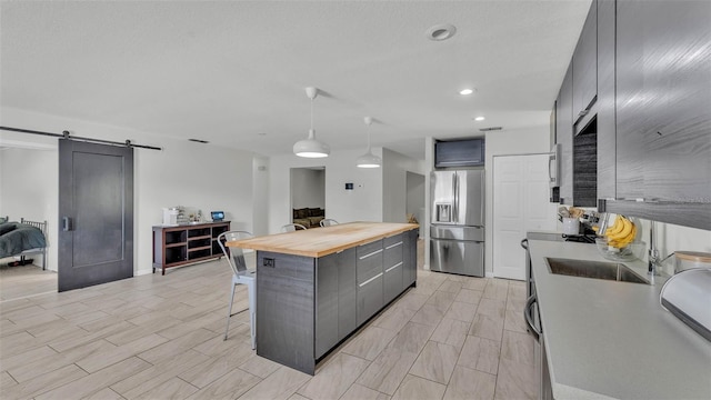 934 Point View Ln, Lakeland, FL 33813 - kitchen with stainless steel refrigerator with ice dispenser, butcher block countertops, a kitchen breakfast bar, a barn door, and gray cabinetry