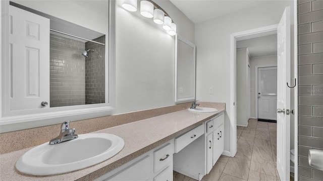 934 Point View Ln, Lakeland, FL 33813 - bathroom featuring marble look tile flooring, double vanity, baseboards, and a tile shower