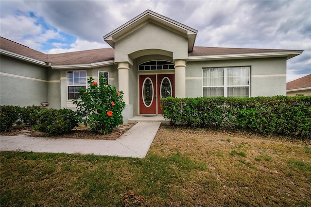 8323 Greystone Dr, Lakeland, FL 33810 - entrance to property with stucco siding, a lawn, and roof with shingles