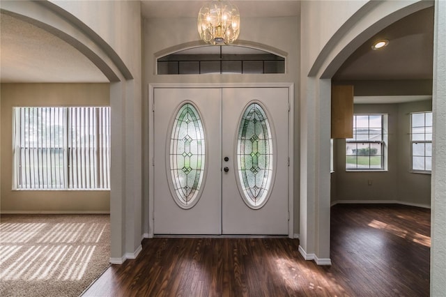 8323 Greystone Dr, Lakeland, FL 33810 - entryway with arched walkways, dark wood-type flooring, baseboards, and a chandelier
