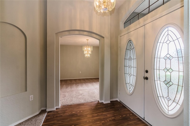 8323 Greystone Dr, Lakeland, FL 33810 - foyer entrance featuring a chandelier, arched walkways, baseboards, and dark colored carpet