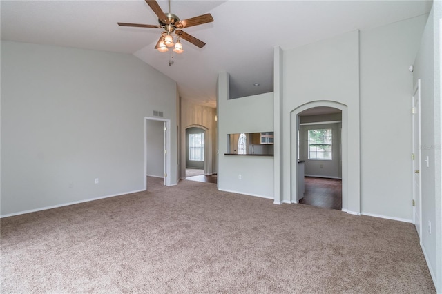 8323 Greystone Dr, Lakeland, FL 33810 - unfurnished living room with arched walkways, carpet floors, a ceiling fan, high vaulted ceiling, and baseboards