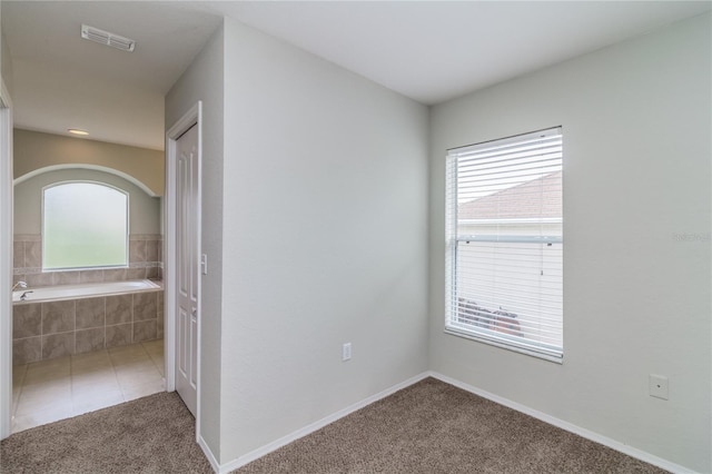 8323 Greystone Dr, Lakeland, FL 33810 - unfurnished bedroom with multiple windows, carpet flooring, and connected bathroom