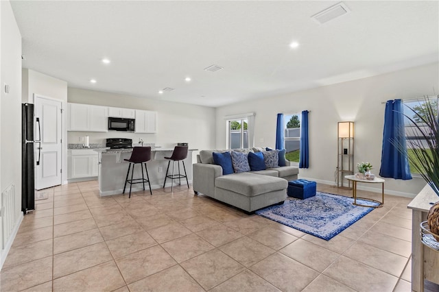 1371 Madison Cir, Haines City, FL 33844 - living room with recessed lighting, light tile patterned floors, and baseboards