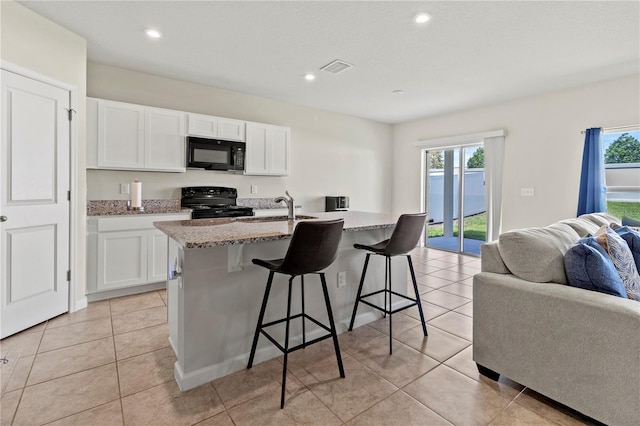 1371 Madison Cir, Haines City, FL 33844 - kitchen with black appliances, open floor plan, a sink, a breakfast bar, and healthy amount of natural light