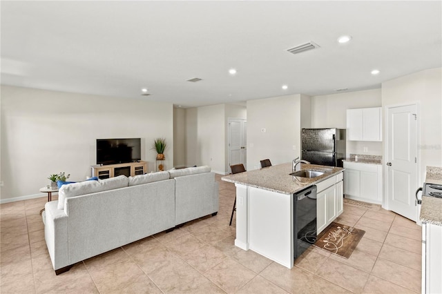 1371 Madison Cir, Haines City, FL 33844 - kitchen featuring dishwasher, a sink, freestanding refrigerator, open floor plan, and a center island with sink
