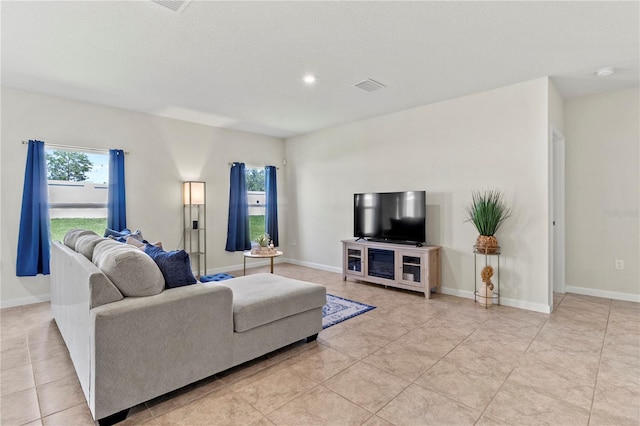 1371 Madison Cir, Haines City, FL 33844 - living area featuring healthy amount of natural light, light tile patterned floors, and baseboards