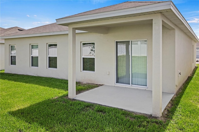 1371 Madison Cir, Haines City, FL 33844 - rear view of house featuring a patio area, stucco siding, a lawn, and roof with shingles