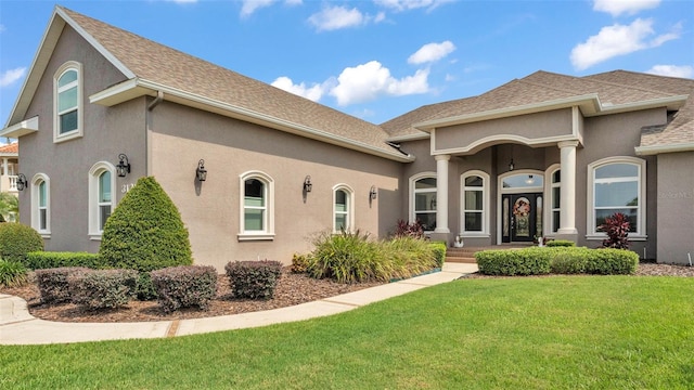 3121 Highlands By The Lake Way, Lakeland, FL 33812 - view of front of house with a front lawn, stucco siding, and roof with shingles