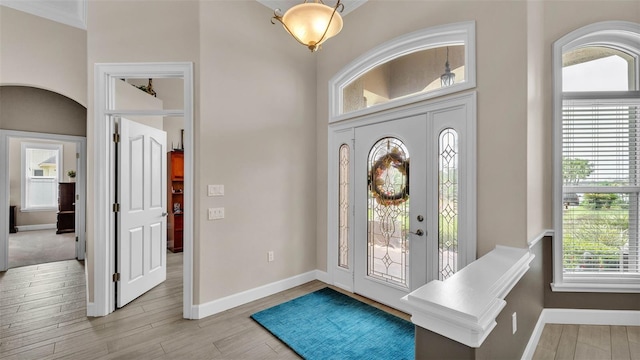 3121 Highlands By The Lake Way, Lakeland, FL 33812 - entryway featuring light wood-type flooring, a high ceiling, arched walkways, and ornamental molding