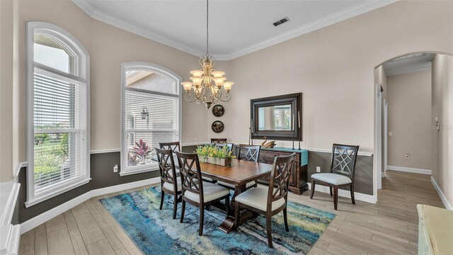 3121 Highlands By The Lake Way, Lakeland, FL 33812 - dining area with arched walkways, ornamental molding, plenty of natural light, light wood-style flooring, and a chandelier