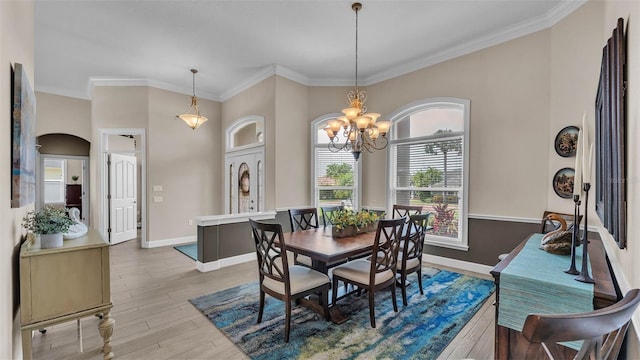 3121 Highlands By The Lake Way, Lakeland, FL 33812 - dining space featuring light wood finished floors, ornamental molding, a chandelier, and arched walkways