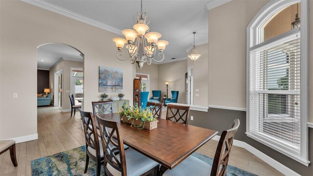 3121 Highlands By The Lake Way, Lakeland, FL 33812 - dining room featuring arched walkways, ornamental molding, hardwood / wood-style floors, and a chandelier