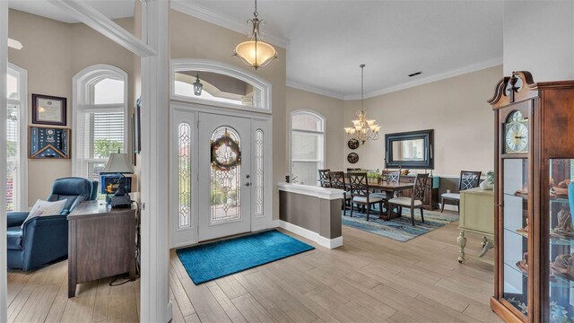 3121 Highlands By The Lake Way, Lakeland, FL 33812 - foyer with a chandelier, light wood-style floors, and ornamental molding