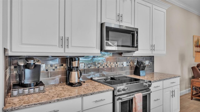 3121 Highlands By The Lake Way, Lakeland, FL 33812 - kitchen featuring stainless steel appliances, ornamental molding, decorative backsplash, white cabinetry, and light stone counters