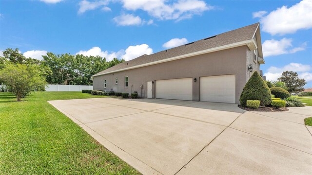 3121 Highlands By The Lake Way, Lakeland, FL 33812 - view of side of home with stucco siding, an attached garage, concrete driveway, and a shingled roof