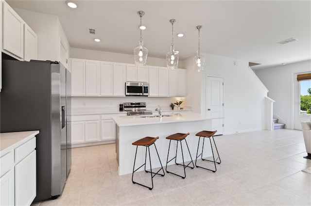 1754 Sanibel Dr, Davenport, FL 33896 - kitchen featuring appliances with stainless steel finishes, a sink, a kitchen bar, white cabinetry, and light countertops