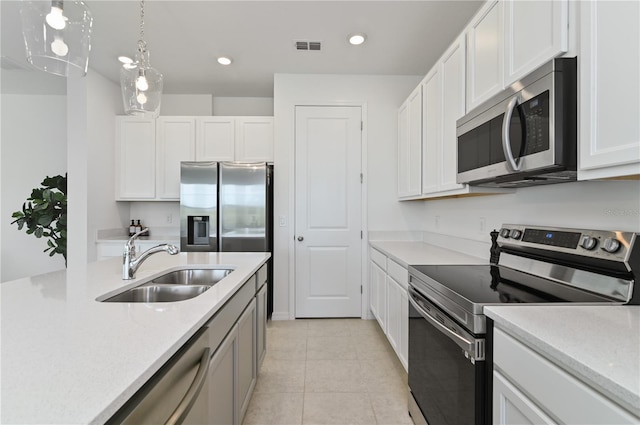 1754 Sanibel Dr, Davenport, FL 33896 - kitchen with stainless steel appliances, a sink, white cabinets, recessed lighting, and light tile patterned flooring