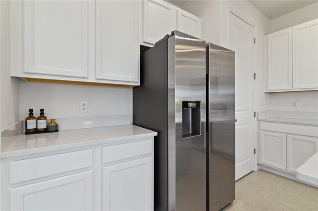 1754 Sanibel Dr, Davenport, FL 33896 - kitchen with stainless steel fridge with ice dispenser, white cabinets, light countertops, and light tile patterned floors