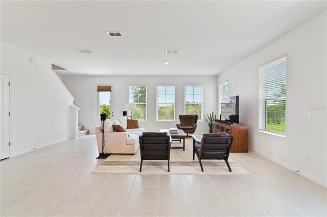 1754 Sanibel Dr, Davenport, FL 33896 - living area featuring light tile patterned floors, plenty of natural light, stairs, and baseboards