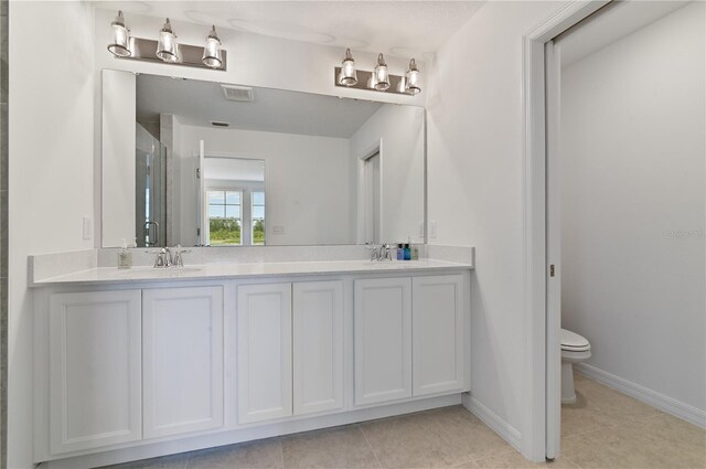 1754 Sanibel Dr, Davenport, FL 33896 - full bath featuring double vanity, toilet, tile patterned flooring, baseboards, and a stall shower