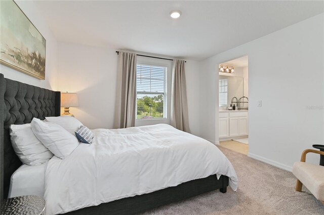 1754 Sanibel Dr, Davenport, FL 33896 - bedroom with light carpet, ensuite bathroom, baseboards, and a sink