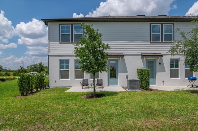 1754 Sanibel Dr, Davenport, FL 33896 - back of house featuring a patio, a lawn, and central AC
