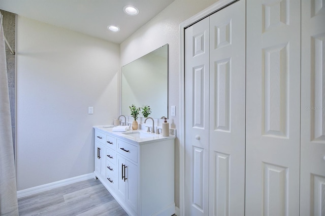 2438 W Wellston Rd, Avon Park, FL 33825 - bathroom with baseboards, double vanity, a closet, wood finished floors, and recessed lighting