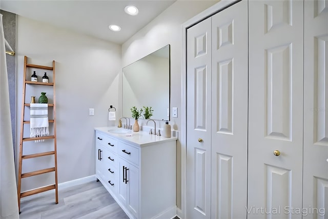2438 W Wellston Rd, Avon Park, FL 33825 - bathroom featuring a closet, double vanity, wood finished floors, recessed lighting, and baseboards